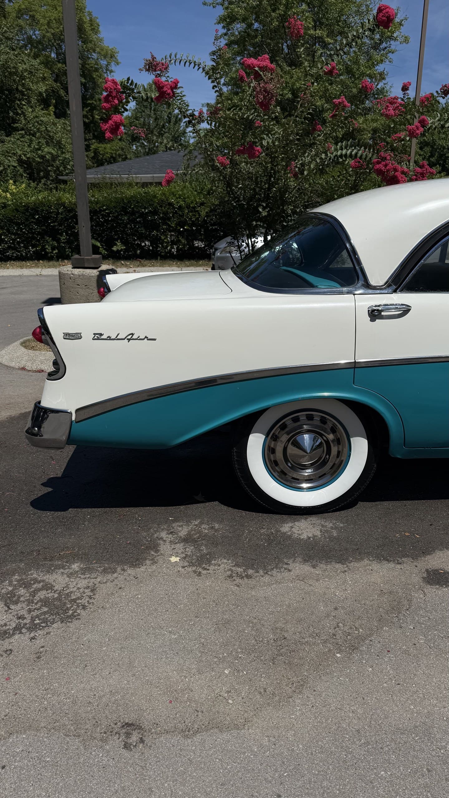 A restored teal and white classic Buick with polished chrome trim
