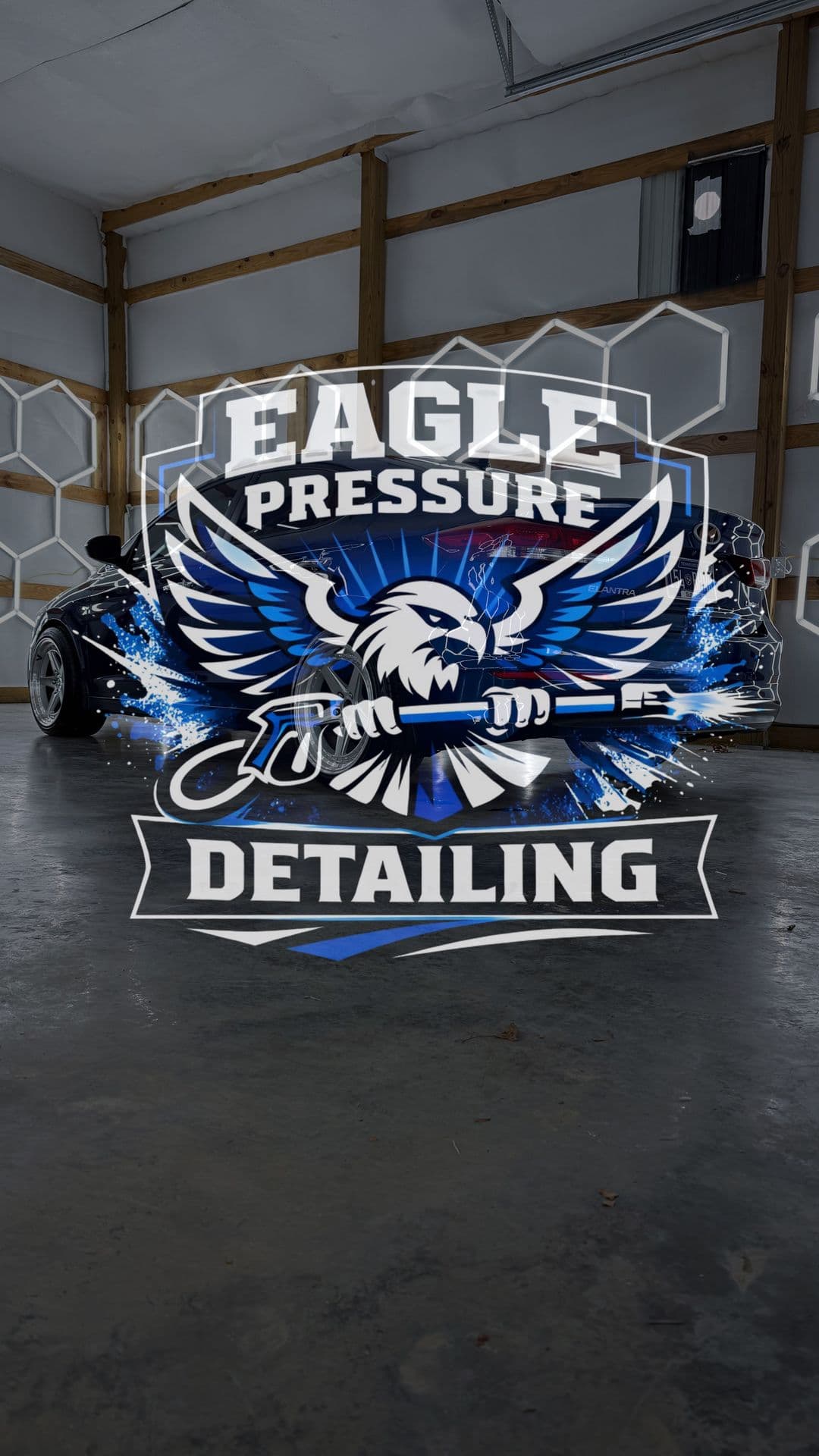 The Eagle Pressure & Detailing banner hanging in the shop bay