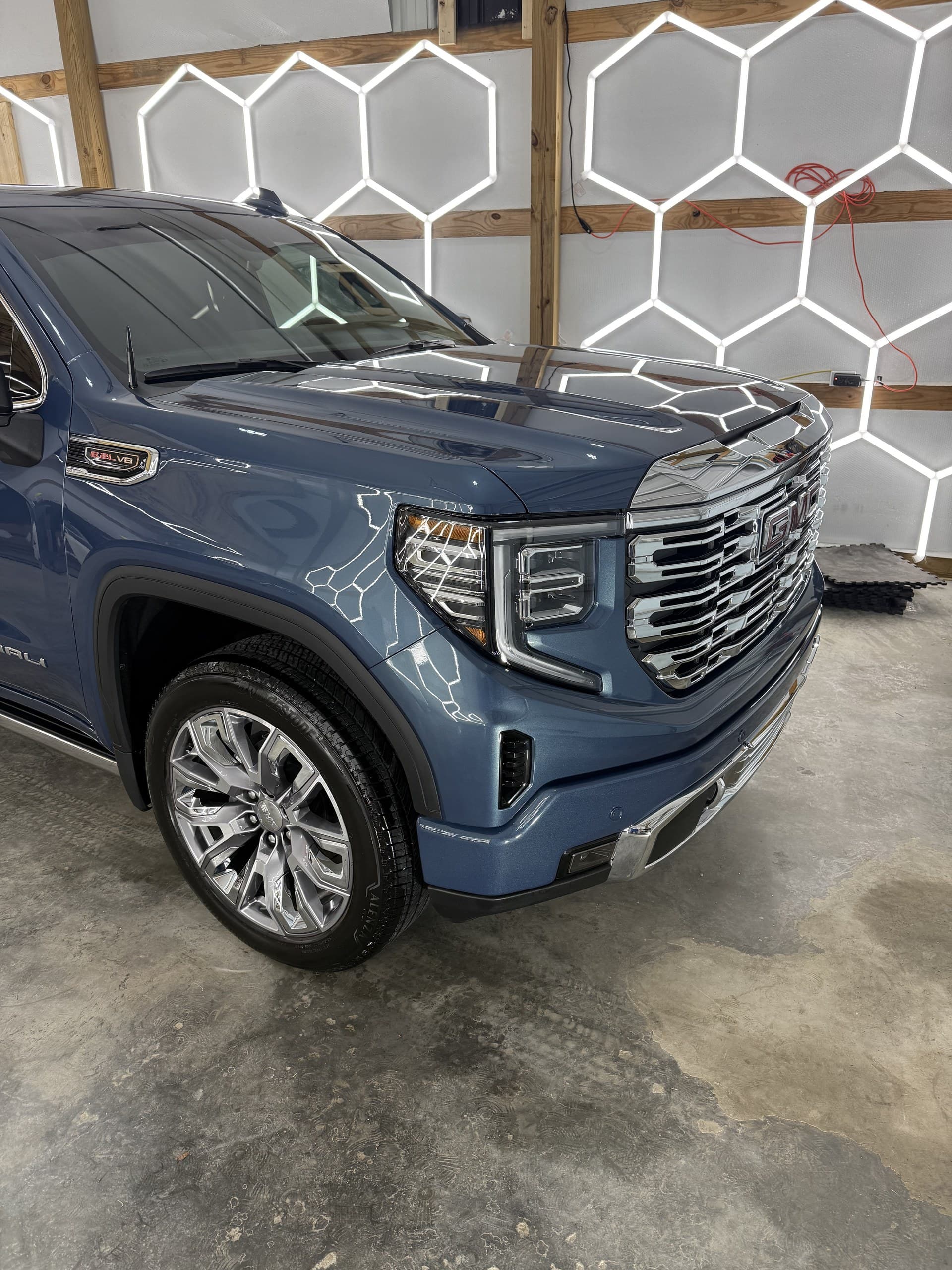 A blue GMC Denali finished and parked under the hex lighting in the Eagle Pressure bay