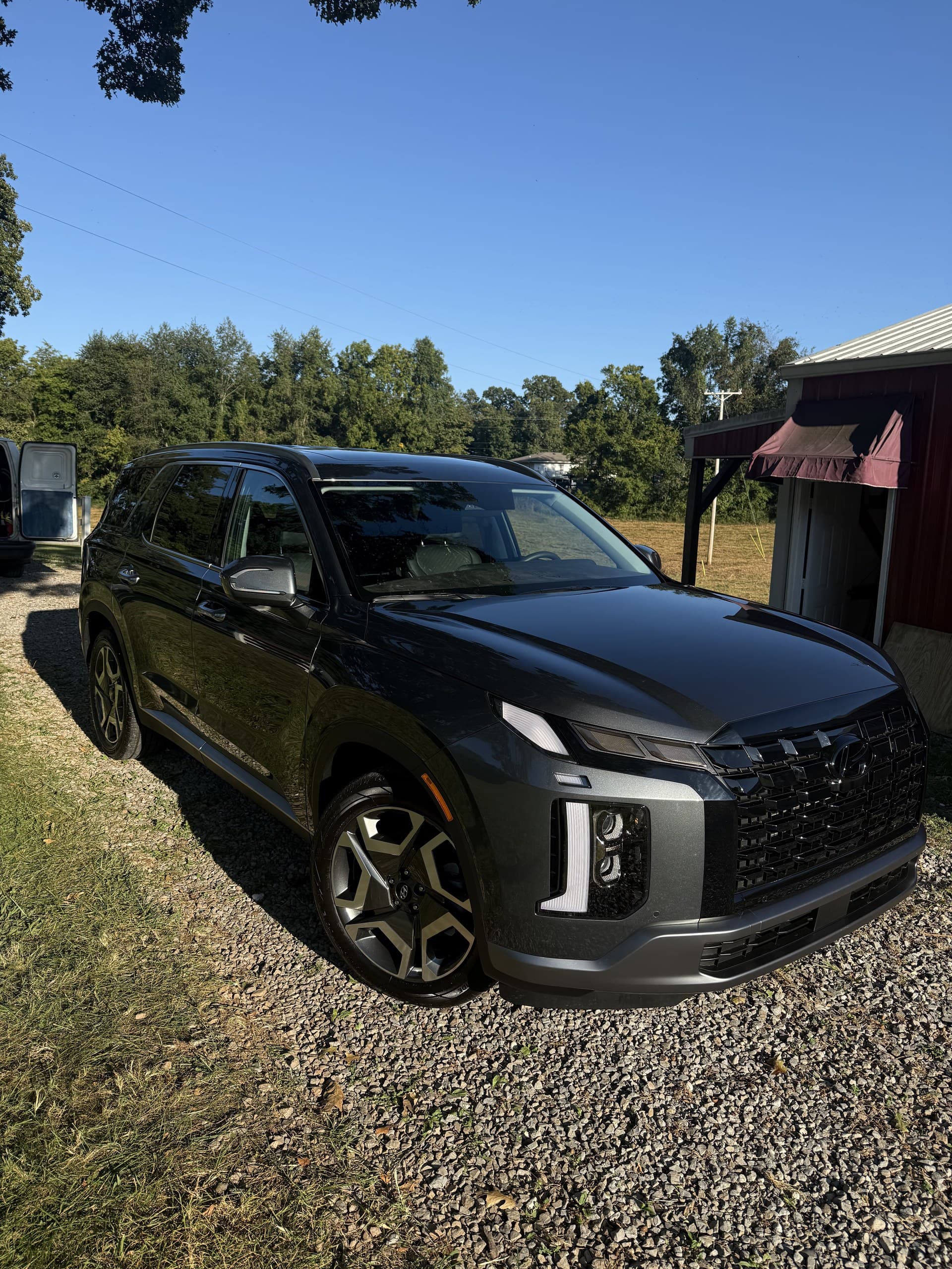 A black SUV detailed on a customer’s gravel driveway